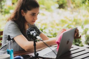 The woman cleans the laptop from dust and bacteria with alcohol spray